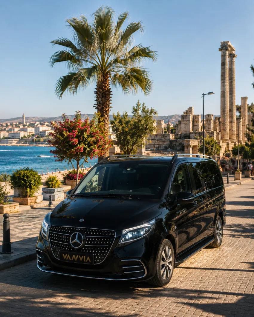 The Vanvia vehicle passing along a palm-lined coastal promenade on the way to Didim