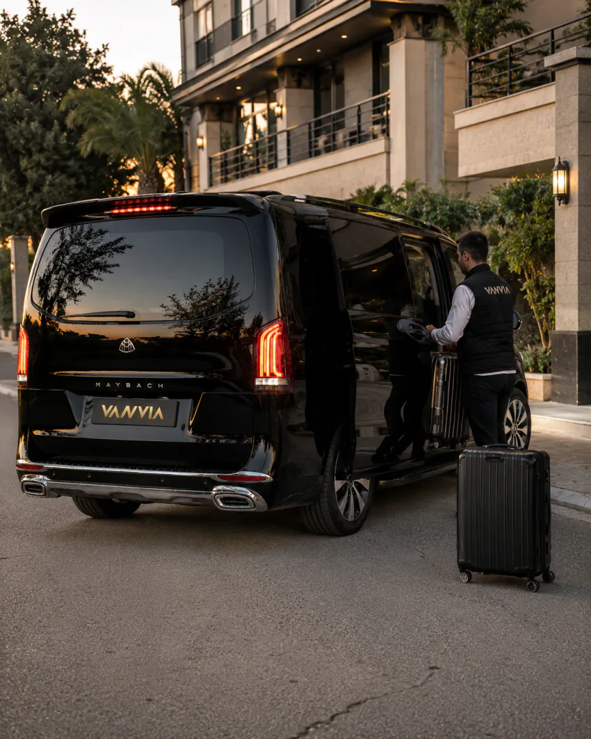 Vanvia driver handling luggage at a residential entrance at night