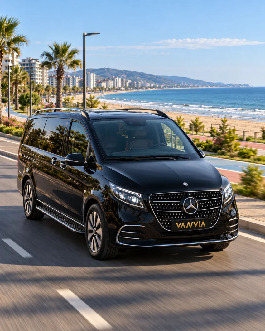 Samsun VIP-Transfer: Schräge Frontansicht eines schwarzen Vanvia-Fahrzeugs auf einer Küstenstraße entlang einer Promenade, eines Radwegs und eines Sandstrands