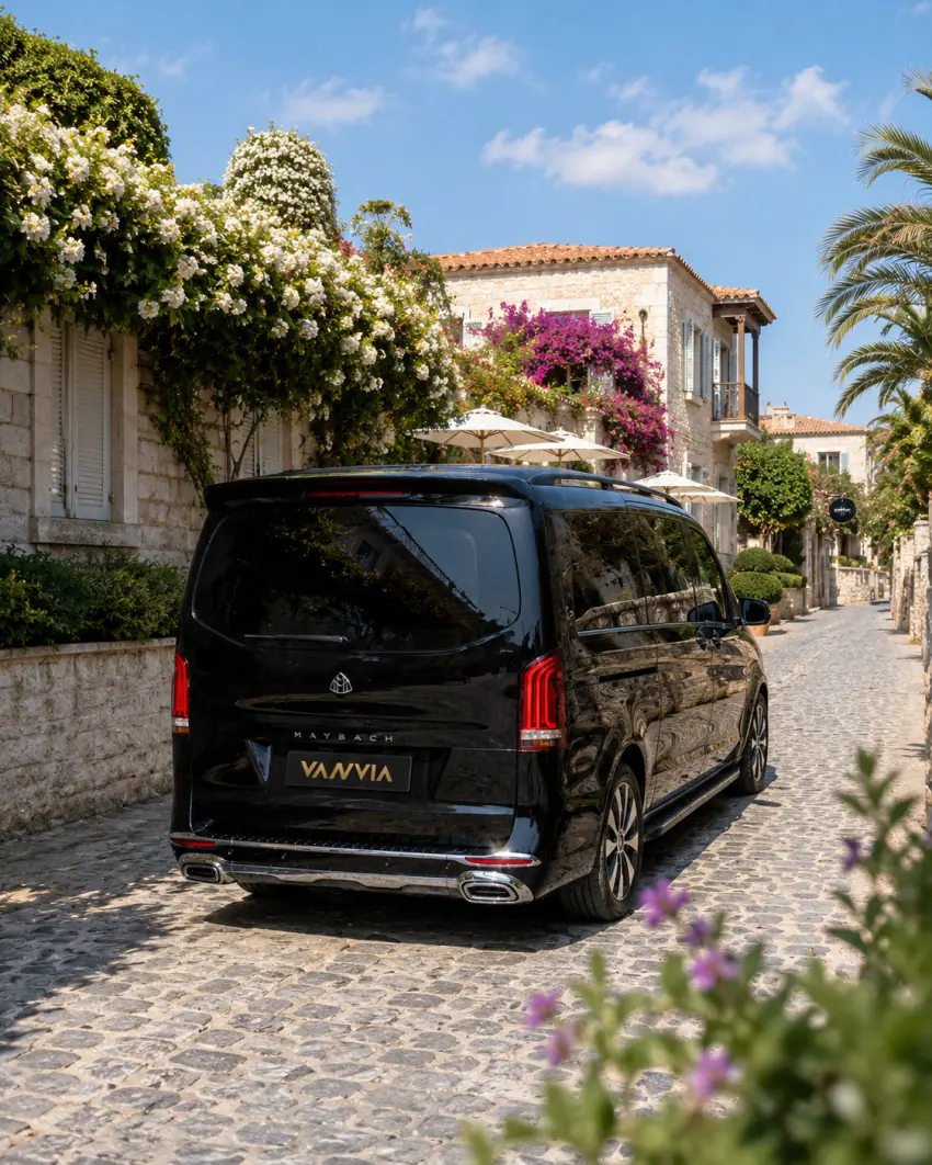 Ein schwarzes Vanvia-VIP-Transferfahrzeug wartet in einer mit Stein gepflasterten Küstenstraße in der Region Izmir