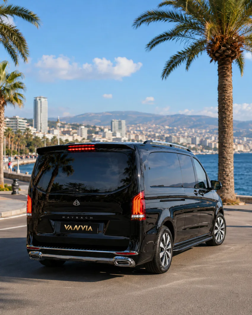 Ein schwarzes Vanvia-VIP-Transferfahrzeug fährt entlang der Kordon-Uferpromenade in Izmir mit Blick auf die Bucht
