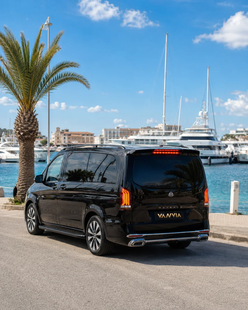Ein schwarzes Vanvia-VIP-Transferfahrzeug wartet vor den Booten an einem Yachthafen